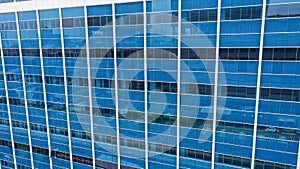 close up of skyscraper glass, abstract building background. View of a modern glass skyscraper reflecting. Blue toned