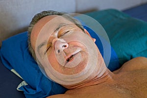 Close up of a sleeping man with a nose tape and open mouth