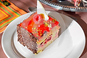 Close-up Slice of Birthday Cake with Fruits on a Table with Plate, Napkin