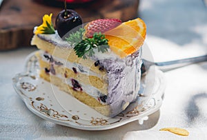 Close up Slice birthday fruit cake in plate violet delicious cream in layer