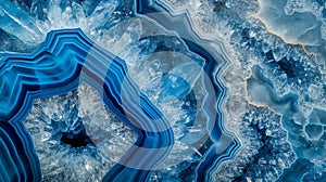 Close-up of a slice of blue agate gemstone, displaying its layers and textures. The background is a solid blue color