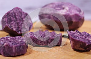 Close-up on a sliced circle of blue potatoes, which lies on a cutting board. Blur effect