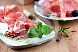 Close up of sliced coppa with herbs