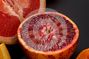 Close up. Sliced in half juicy blood orange on a black background