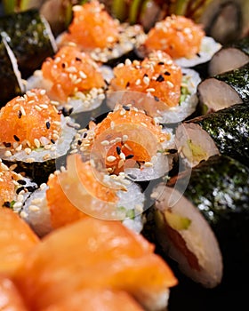 Close up of sliced maki rolls stuffed with fresh salmon, cucumbers and sesame seeds.