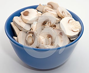 Close up sliced mushrooms in blue bowl