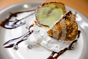 Fried ice cream with chocolate syrup and cream on plate