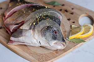 Close up of  sliced raw carp with peppers and lemon on cutting board. Cooking fish