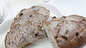 Close-up of sliced rye raisin bread on the white cutting board.