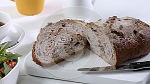 Close-up of sliced rye raisin bread on the white cutting board.