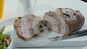 Close-up of sliced rye raisin bread on the white cutting board