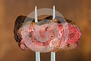 close-up sliced steak impaled on meat fork