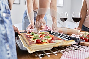 Close up of slicing delicious homemade pizza on the table