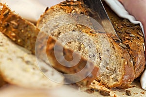 Close up of Slicing Wholemeal Seeded Bread Loaf