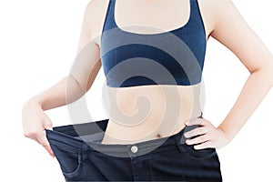 Close-up of slim waist of young woman in big jeans showing successful weight loss, isolated on white background