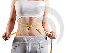 Close up of slim woman measuring her waist`s size with tape measure