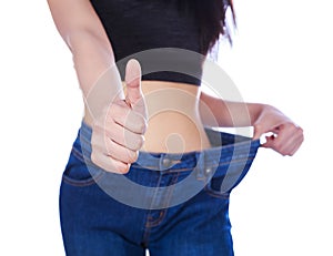 Close up slim woman in old jeans showing thumbs up isolated on w