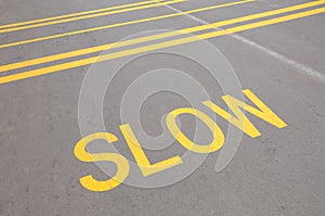 Close up on a slow down speed indicator sign painted on a road