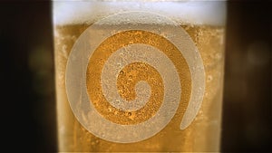 Close-up slow-motion Cold Light Beer in a glass with water drops on bar background. Craft Beer close up. Microbrewery