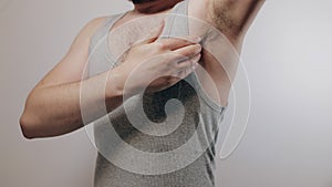 Close up slow motion shoot of man touching his hairy armpit and showing thumb up. Refusal of depilation or shaving. Beauty standar