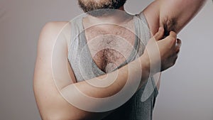 Close up slow motion shoot of strong man in sweaty shirt touching hairy armpits. Refusal of depilation or shaving. Beauty standard