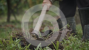 Close-up slow motion shot of farmer hands using a hoe an agriculture hand tool digging and moving soil preparing for young tree