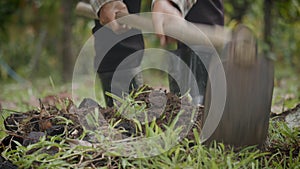 Close-up slow motion shot of farmer hands using a hoe an agriculture hand tool digging and moving soil preparing for young tree