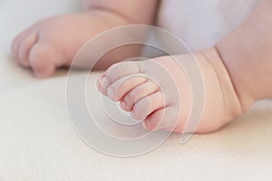 Close up of small baby feet on white background