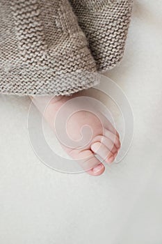 Close up of small baby foot under blanket