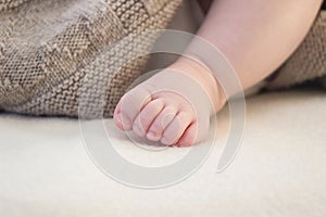 Close up of small baby foot under blanket