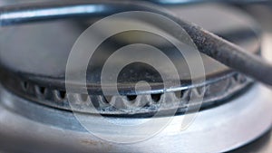 Close-up of small blue flame of gas on a gas stove. Action. Meal preparation