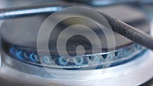 Close-up of small blue flame of gas on a gas stove. Action. Meal preparation