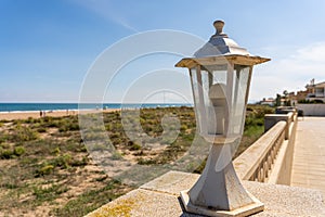 Close up of a small decorative lamppost on the exterior wall of a house near the beach photo
