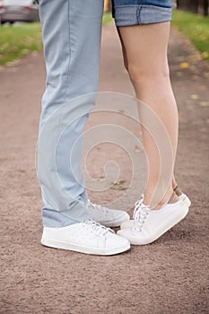 Close up of small girlfriend standing tiptoe to kiss lover
