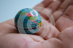 Small globe in hand symbolizing global connection.