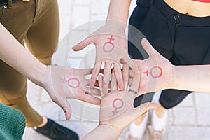 close up of small group of women with the symbol of feminism written on her hands photo