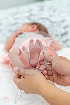 Close-up of the small legs of a newborn baby in the hands of a woman or mother. Moments with a child