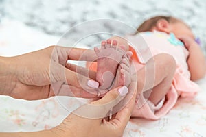 Close-up of the small legs of a newborn baby in the hands of a woman or mother. Moments with a child