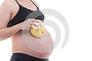 Close up Small yellow shoes for the unborn baby in the belly of