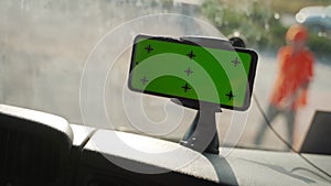 Close up of smart phone in car interior mock up with green screen and tracking points. Concept of riding a truck lorry