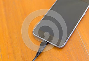 Close up of smart phone charging with USB cable