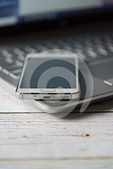 Close up of smart phone on a laptop keyboard