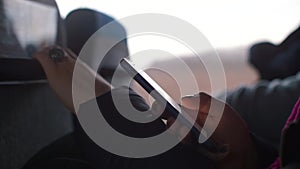 Close-up of a smartphone in the hands of a woman in a public transport bus.