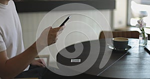 Close-up of smartphone in male hands tapping on screen. Man scanning QR code on table in restaurant or cafe. Online menu