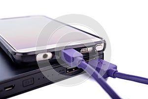 Close up of smartphone mobile charging by power bank with purple or violet usb cable isolated on white background