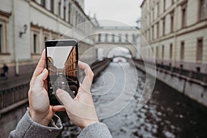 Close up of smartphone taking photo of beautiful tourist landscape in Sant-Petersburg