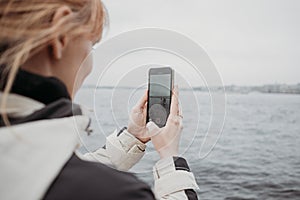 Close up of smartphone taking photo of beautiful tourist landscape in Sant-Petersburg