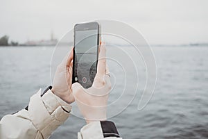 Close up of smartphone taking photo of beautiful tourist landscape in Sant-Petersburg