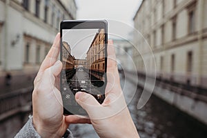 Close up of smartphone taking photo of beautiful tourist landscape in Sant-Petersburg