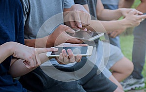 Close-up of smartphones in the hands of women sitting outdoors. Meeting friends. Girls using digital gadgets.